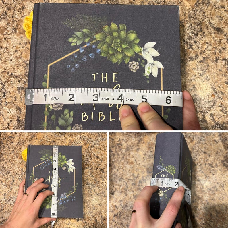 May include: A dark grey book titled "The Holy Bible" with floral and geometric designs. The book is being measured with a tape measure, showing a width of approximately 10 cm and a height of approximately 20 cm.