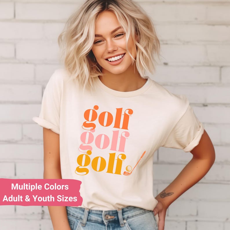May include: A white t-shirt with the word "golf" repeated three times in orange, pink, and yellow. The word "golf" is stacked vertically with a golf club and ball to the right.