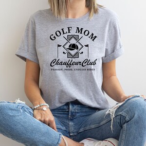 Woman wearing gray “Golf Mom Chauffeur Club” tee with black lettering. Relaxed golf mom shirt for women, perfect casual gift for golf season.
