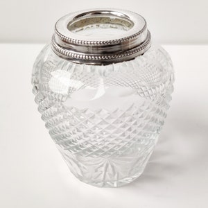 May include: A clear glass vase with a silver rim and a cut glass design.