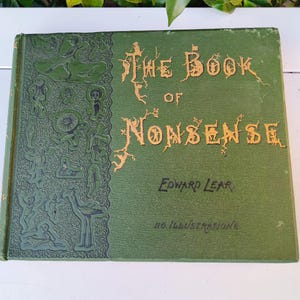 Op de afbeelding: Een vintage hardcover boek getiteld "The Book of Nonsense" van Edward Lear. De groene kaft heeft gouden letters en illustraties. Het boek is in goede staat, met wat slijtage zichtbaar.