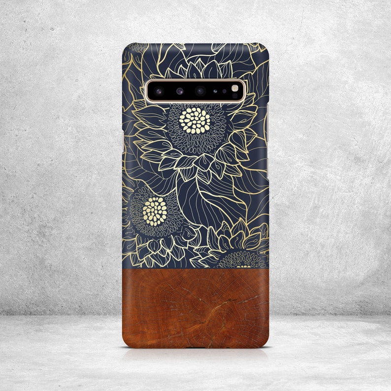 May include: A navy blue phone case with a gold floral design and a brown wood-grain bottom.