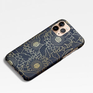 May include: A navy blue phone case with a gold sunflower pattern. The case has a cutout for the camera lens.