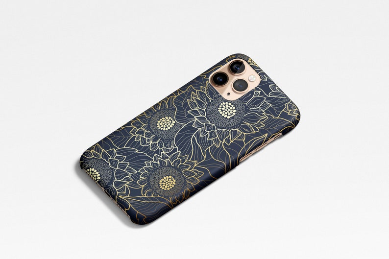 May include: A navy blue phone case with a gold sunflower pattern. The case has a cutout for the camera lens.