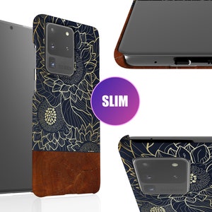 May include: A slim phone case with a navy blue background and a gold floral design. The case has a brown leather bottom and a cutout for the camera lens.