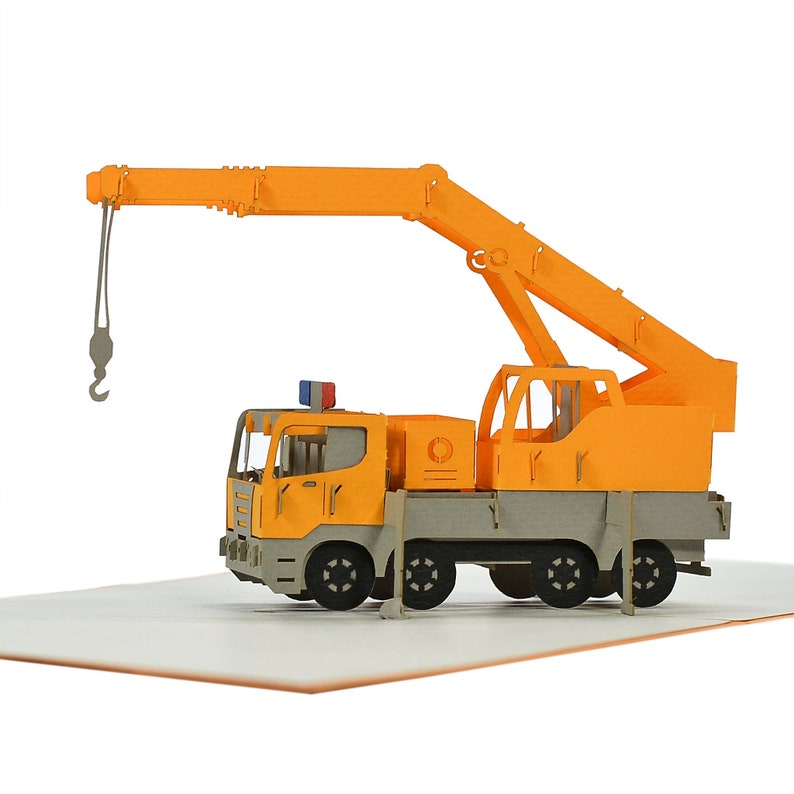 May include: A yellow and gray 3D pop-up card of a construction crane truck. The crane is extended and the hook is lowered. The truck has a gray cab and a yellow body.