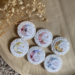 May include: Six round white soaps with colorful floral designs and the text "Eid Mubarak" on each soap.