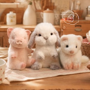 May include: Three plush animal toys sitting in a row: a light pink piglet, a fluffy white lop-eared rabbit, and a small white ferret. Above the rabbit is a hand-drawn white thought bubble containing a simple line illustration of a strawberry cake.