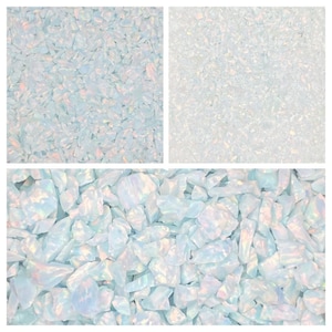 Könnte beinhalten: Nahaufnahme von irisierenden weißen Opal-Chips. Die Chips sind in verschiedenen Größen und Formen, mit einem hellblauen Hintergrund.