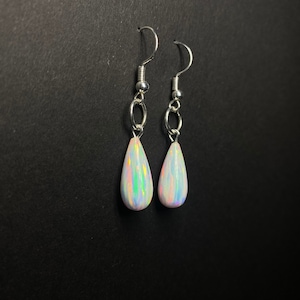 May include: A pair of silver teardrop earrings with iridescent white opal stones.