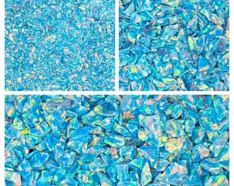 May include: A close-up image of iridescent blue and green glitter. The glitter is made of small, irregular pieces of glass. The glitter is perfect for adding sparkle to crafts, nail art, and other projects.