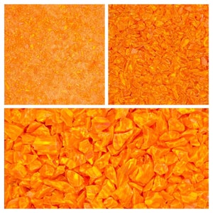 May include: A close-up image of orange, irregularly shaped, translucent pieces of glass. The pieces are scattered randomly and create a textured surface.