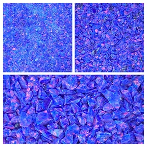 Può includere: Un'immagine ravvicinata di una collezione di piccoli pezzi di vetro blu e viola iridescenti. I pezzi di vetro sono disposti in uno schema casuale, creando una superficie testurizzata.