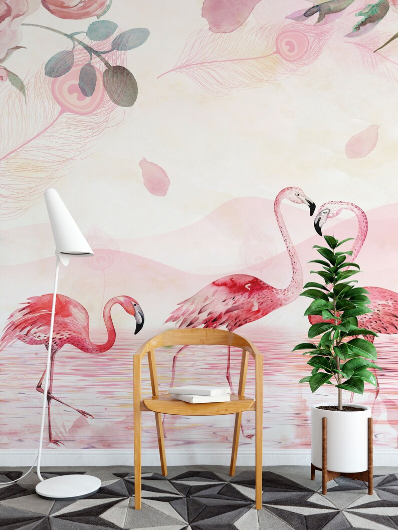 May include: A watercolour wall mural featuring pink flamingos standing in a pink and white water scene. The mural is decorated with pink feathers and rose petals. A wooden chair and a potted plant are in the foreground.