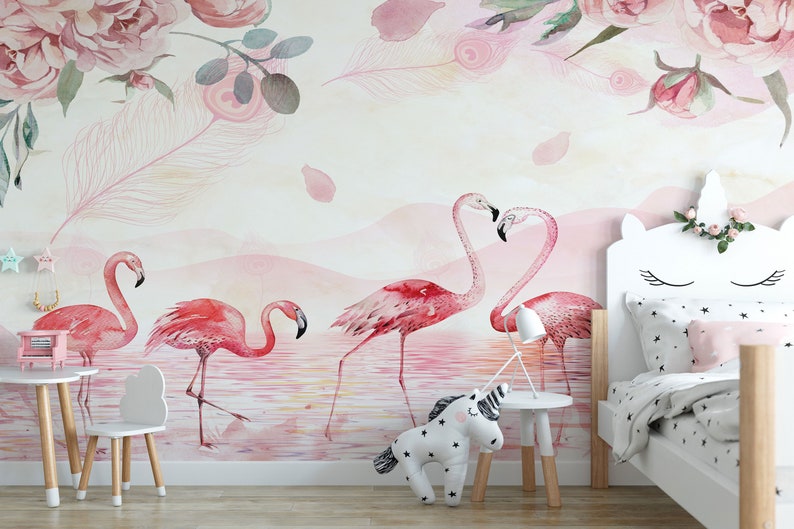 May include: A pink and white nursery with a unicorn headboard on a bed with a pink and white star patterned duvet. The wall has a pink watercolour mural with pink flamingos and pink flowers.