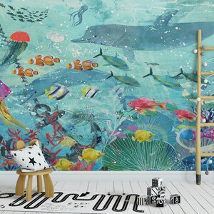 May include: A colorful underwater mural featuring a large blue dolphin, coral reefs, jellyfish, and various fish. The mural is painted on a light blue background with white speckles. A wooden ladder and a small wooden stool with a star-patterned cushion are in the foreground.