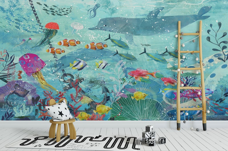 May include: A colorful underwater mural featuring a large blue dolphin, coral reefs, jellyfish, and various fish. The mural is painted on a light blue background with white speckles. A wooden ladder and a small wooden stool with a star-patterned cushion are in the foreground.