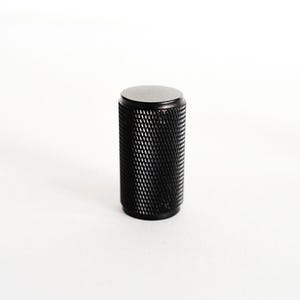 May include: Black metal cabinet knob with a diamond pattern.