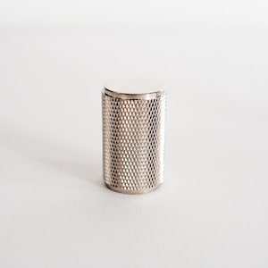 May include: A silver metal knob with a diamond pattern.