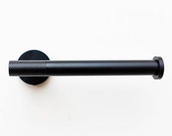 May include: Black metal toilet paper holder with a textured cylindrical bar and a round base.