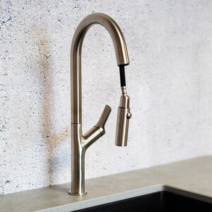 May include: A brushed nickel kitchen faucet with a pull-down sprayer and a single lever handle.