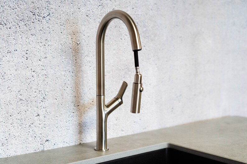 May include: A brushed nickel kitchen faucet with a pull-down sprayer and a single lever handle.