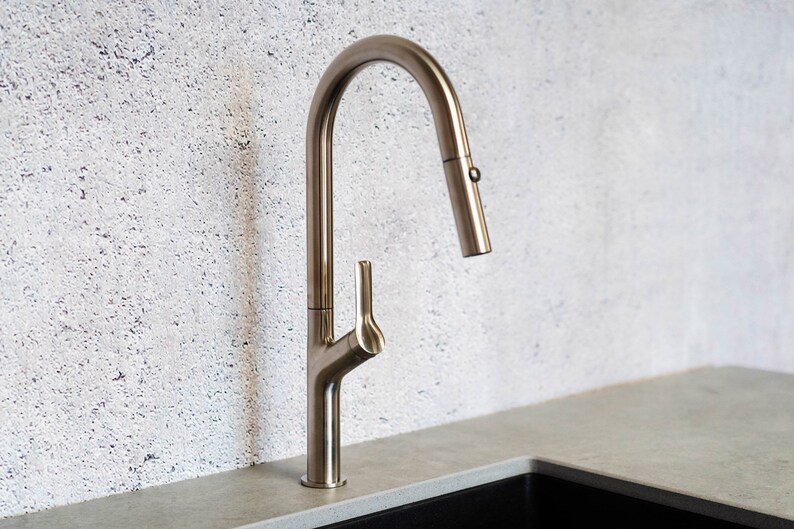 May include: A brushed nickel kitchen faucet with a pull-down sprayer and a single lever handle.