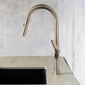 May include: A brushed nickel kitchen faucet with a pull-down sprayer and a single lever handle.