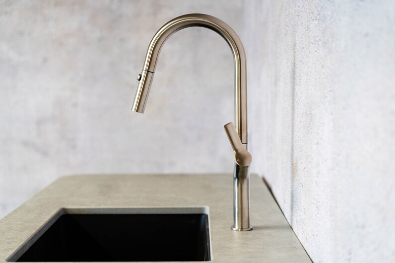 May include: A brushed nickel kitchen faucet with a pull-down sprayer and a single lever handle.