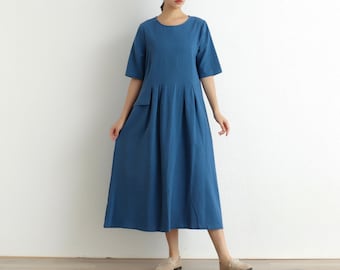 May include: A blue midi dress with a round neckline and short sleeves. The dress has a pocket on the left side and a pleated skirt.
