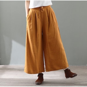 May include: Wide-leg, mustard yellow linen pants with a drawstring waist and pockets.