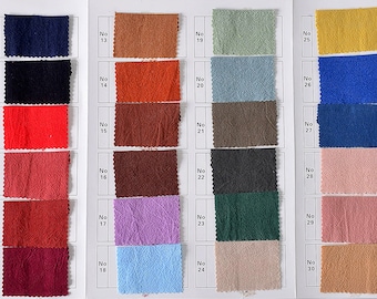 May include: A fabric swatch card displaying 36 different fabric samples. The samples are arranged in rows of four, with each row labelled with a number. The fabric samples are a variety of colours, including white, black, red, orange, brown, purple, blue, green, yellow, and pink.