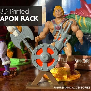May include: 3D printed weapon rack for action figures. The rack is made of brown plastic and features a gray shield, a silver sword, and a gray axe. The text "FIGURES AND ACCESSORIES NOT INCLUDED" is printed at the bottom of the image.