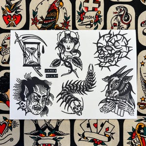 May include: A white sheet featuring traditional tattoo flash art. The designs include an hourglass, a rose with a woman's face, a skull, a demon face, a centipede, and a goat playing a flute. The artist's name, James Wilby, is printed below the designs.