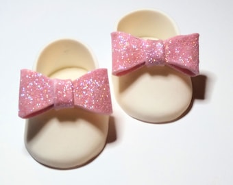 Baby girl shoe with pink glitter bow cake topper made of fondant/gum paste. Baby shower decoration