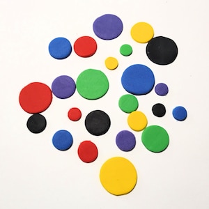 May include: A collection of colorful circles made of playdough in various shades of red, blue, green, yellow, purple, and black.