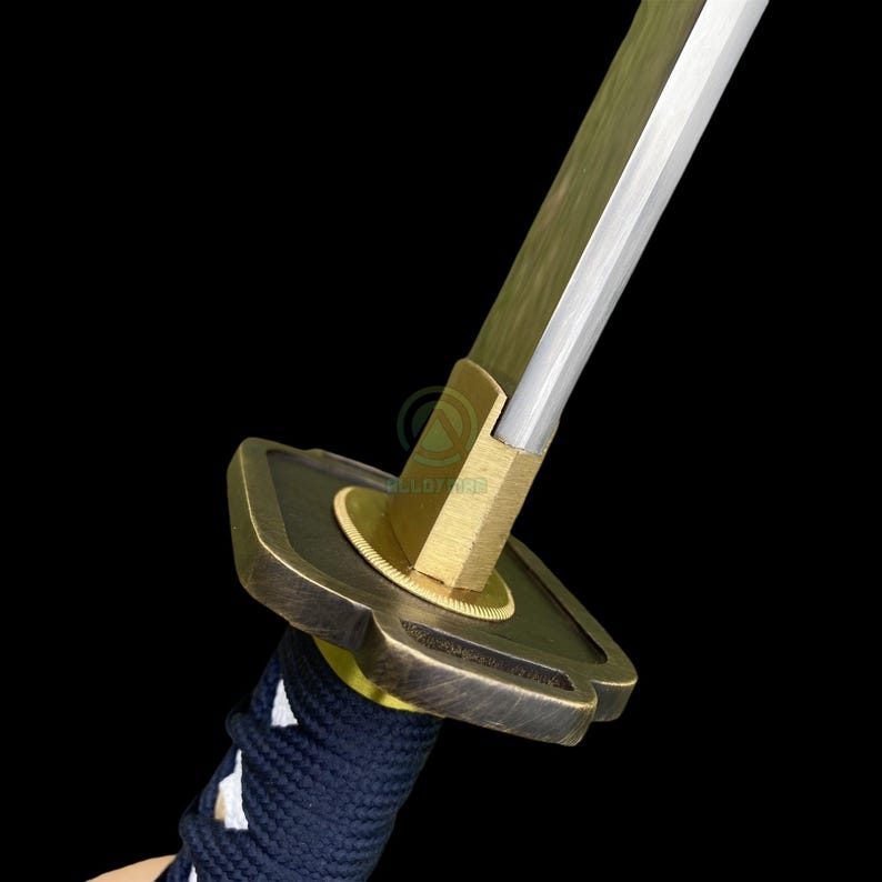 Może przedstawiać: Zbliżenie na miecz katana. Ostrze jest srebrne, a osłona jest brązowa z okrągłym wzorem. Rękojeść jest owinięta ciemnoniebieską tkaniną. Miecz jest umieszczony na czarnym tle.