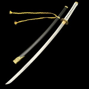 May include: A Japanese katana sword with a white blade and a black handle. The sword is partially sheathed in a black scabbard with gold accents. A gold and yellow cord is tied to the scabbard.