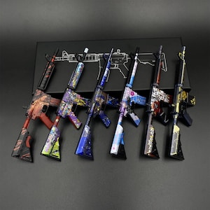 May include: Six miniature toy rifle models arranged in a row, each featuring distinct colourful graphic patterns including red, purple, blue, and gold designs. The rifles are displayed in front of a black box with a white line drawing of a rifle.