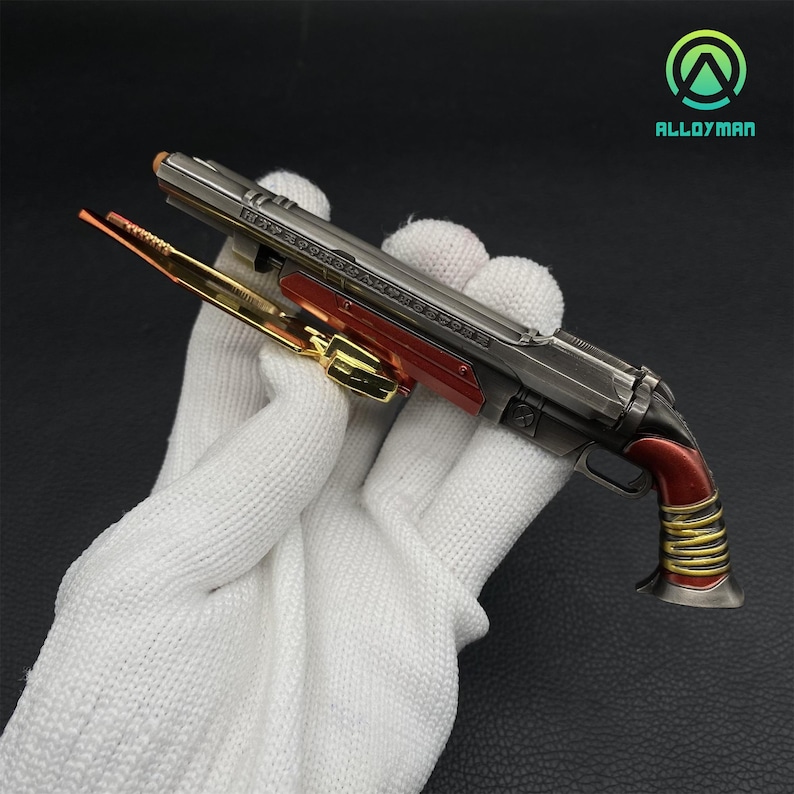 Pu&ograve; includere: Una replica di fucile a pompa in metallo argentato e rosso con dettagli dorati. L'arma ha un design dettagliato ed &egrave; tenuta in una mano guantata di bianco.