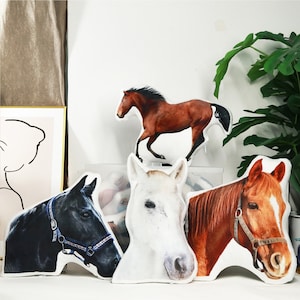 May include: Four plush horse cushions in different colours and designs. The cushions are made of soft fabric and have realistic horse features.