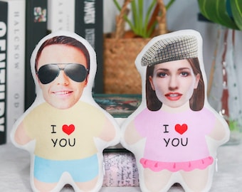 May include: Two personalized plush pillows with faces printed on them. The pillows are wearing clothes and have the text "I love you" printed on them.