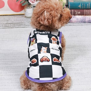 May include: A brown and white dog vest with a checkered pattern and images of dogs. The vest has a purple trim and the text "niuniu", "cute", and "clever" printed on it.