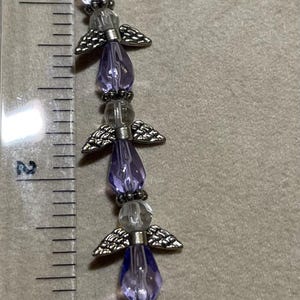 Angels, Glass Beads and metal wings.  Sapphire & Silver, Each angel 1/2”, 13 per string,