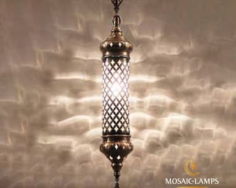 Puede incluir: Una lámpara colgante decorativa con un marco de metal y una pantalla de vidrio transparente. La lámpara tiene 10 cm de ancho y 60 cm de alto.