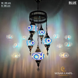 May include: A blue mosaic glass chandelier with five lights. The chandelier is 39 inches wide and 38.5 inches tall. The lights are surrounded by a decorative metal frame.