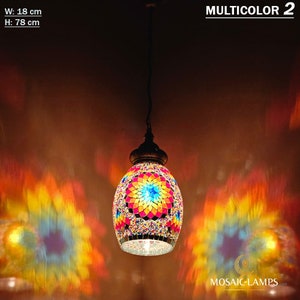 May include: Multicolored mosaic glass pendant light with a starburst design. The light is hanging from a black cord and is casting a colorful light pattern on the wall. W: 18 cm, H: 78 cm. MULTICOLOR 2.