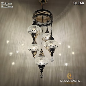 May include: A 5-light chandelier with clear glass globes and a brass finish. The chandelier is 41 cm wide and 103 cm high. CLEAR is written in the top right corner of the image.