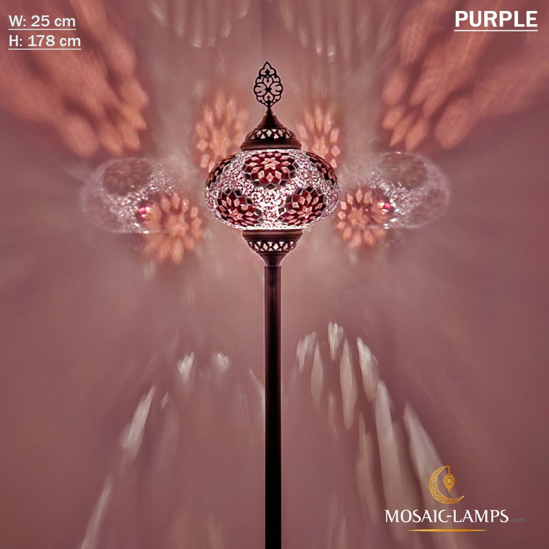 May include: A tall, purple floor lamp with a mosaic glass shade. The lamp is 25 inches wide and 70 inches tall. The shade has a geometric pattern and is lit from within. The lamp is on a white background.