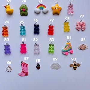 Puede incluir: Una colecci&oacute;n de coloridos abalorios, que incluyen un pato amarillo, una rana verde, un arco&iacute;ris, una estrella, ositos de goma, un lazo rosa, un pat&iacute;n, una nube, una abeja y una bota de vaquero rosa. Ideal para la creaci&oacute;n de joyas.